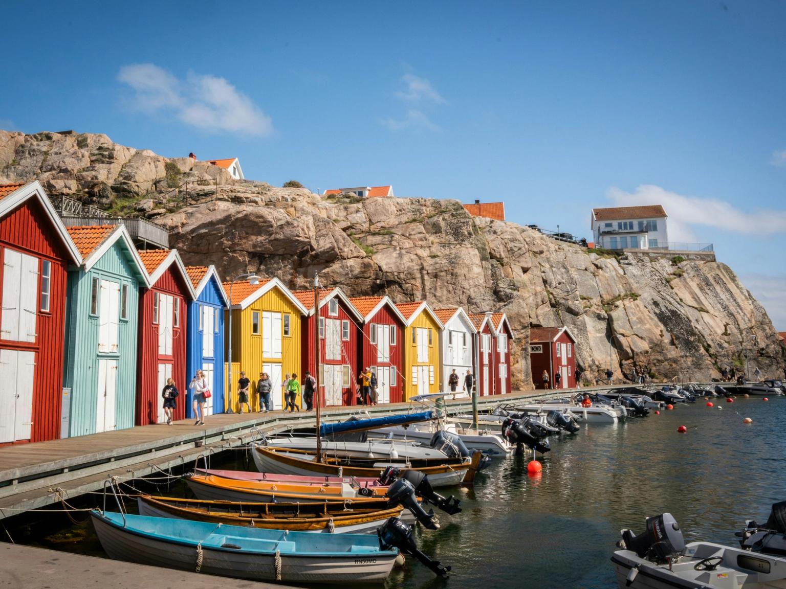 une rangée de maisons colorées sont alignées les unes à côté des autres sur un quai