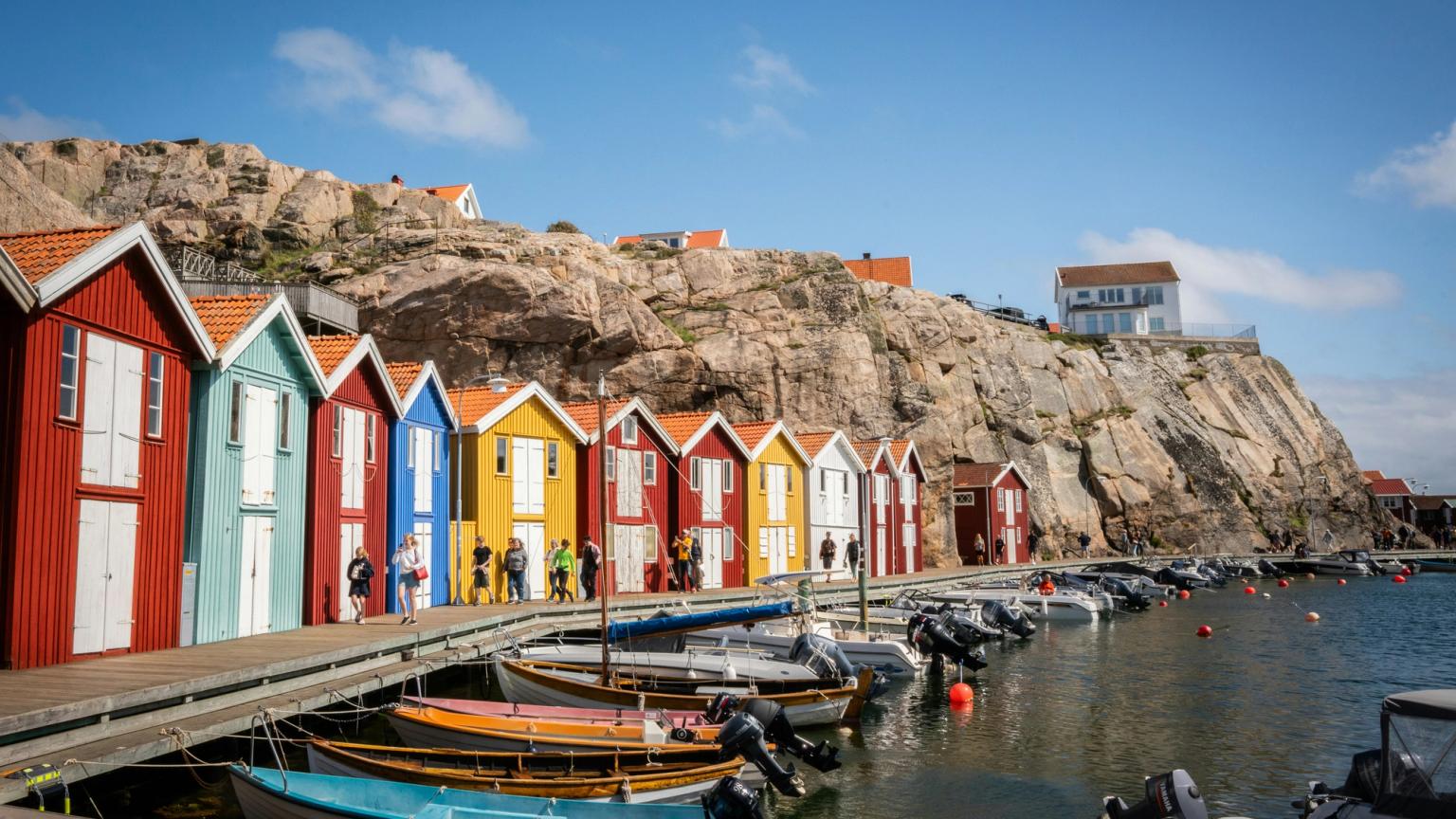 en rekke fargerike hus er stilt opp ved siden av hverandre på en dock