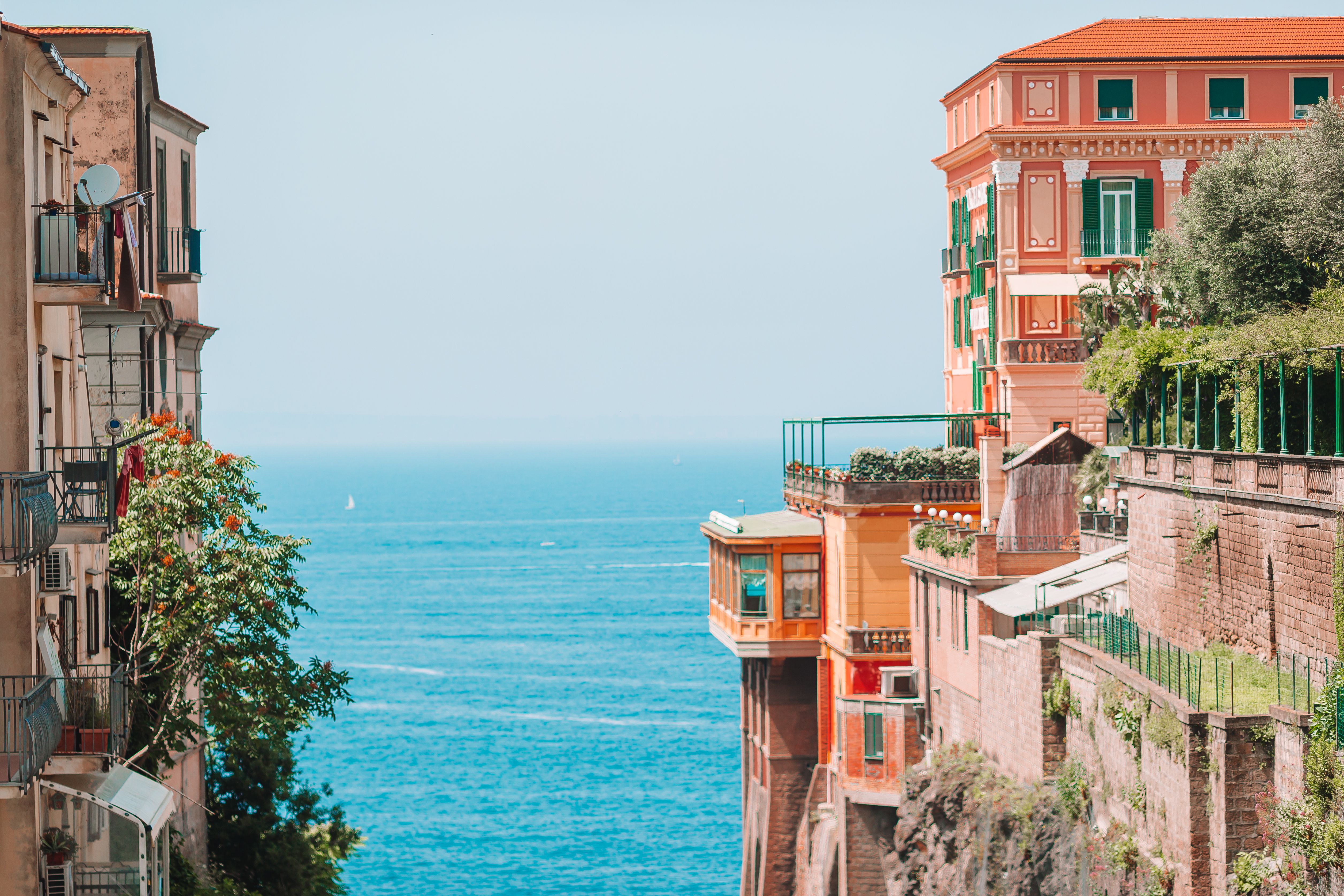 Bunte Gebäude auf Klippen mit Blick auf ein strahlend blaues Meer. Sorrento, Italien