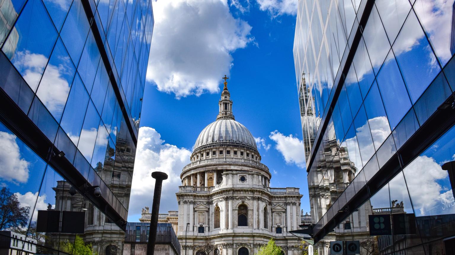en stor byggnad med en kupol speglas i fönstren på en byggnad