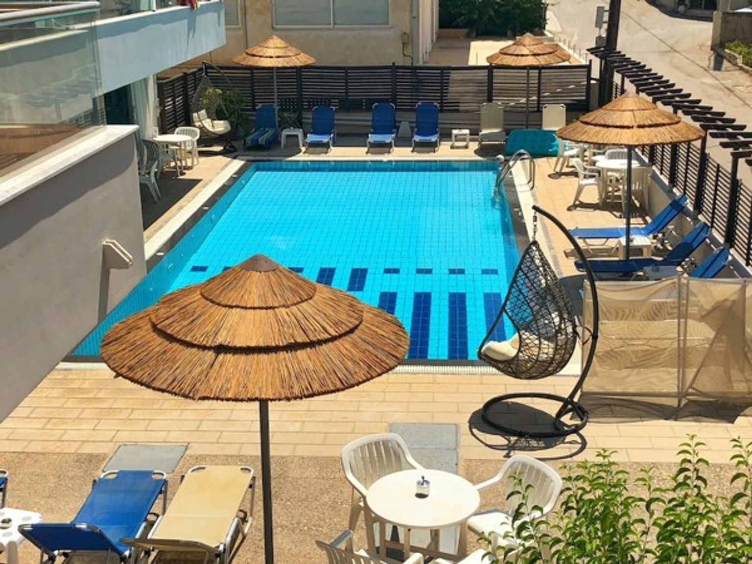 en stor simbassÀng omgiven av stolar, bord och paraplyer