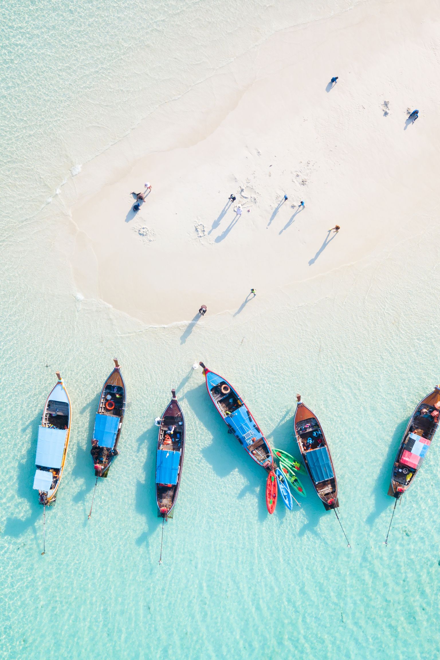 en luftig utsikt over en gruppe båter som sitter på toppen av en sandstrand