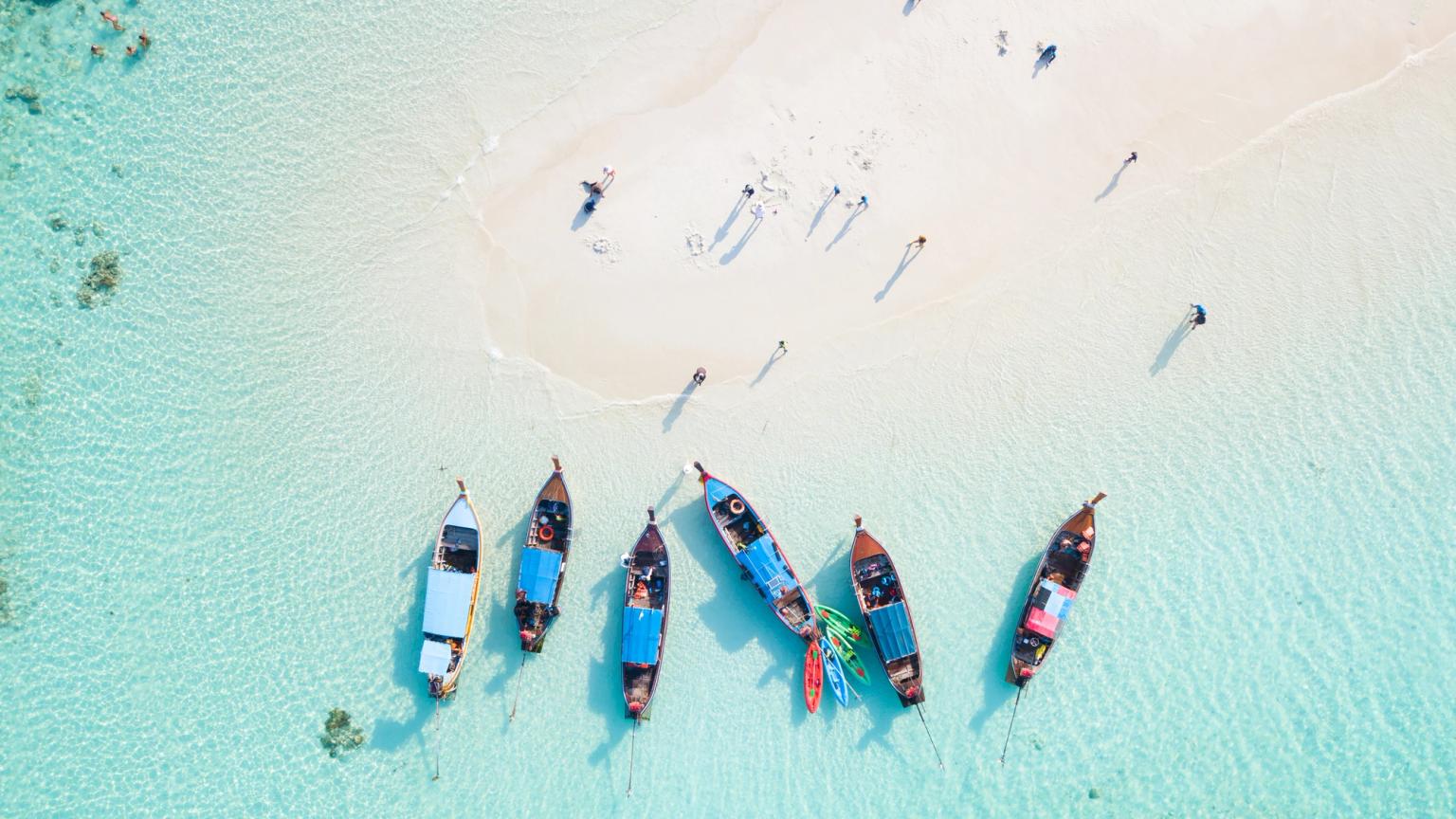 en luftvisning af en gruppe både, der sidder på toppen af en sandstrand