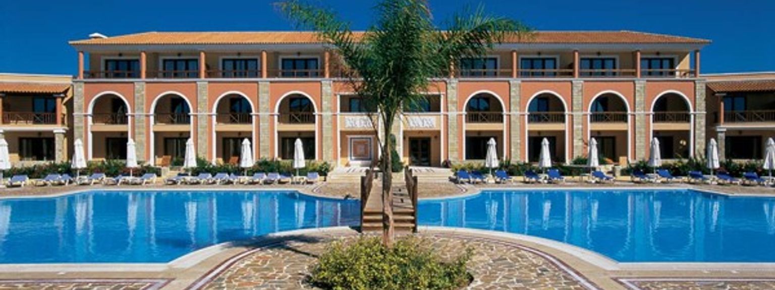 ett stort hotell med en stor simbassäng framför det