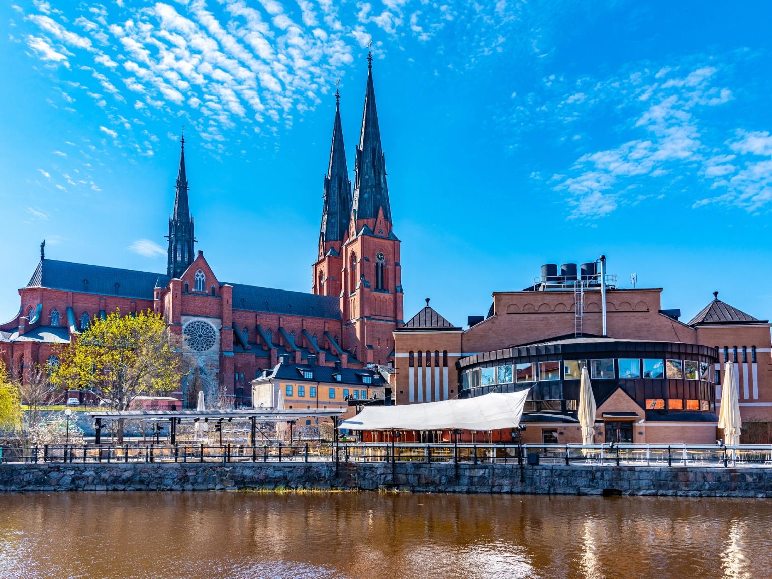 en stor röd katedral ligger bredvid en flod i en stad