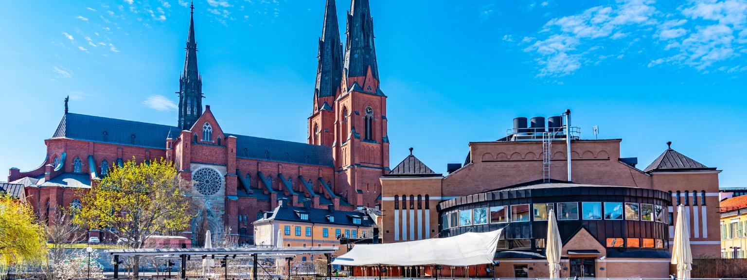 en stor röd katedral ligger bredvid en flod i en stad