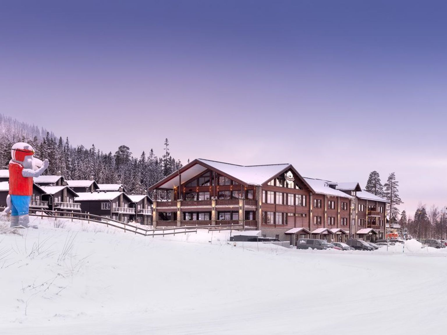 a snowman is standing in front of a large building covered in snow