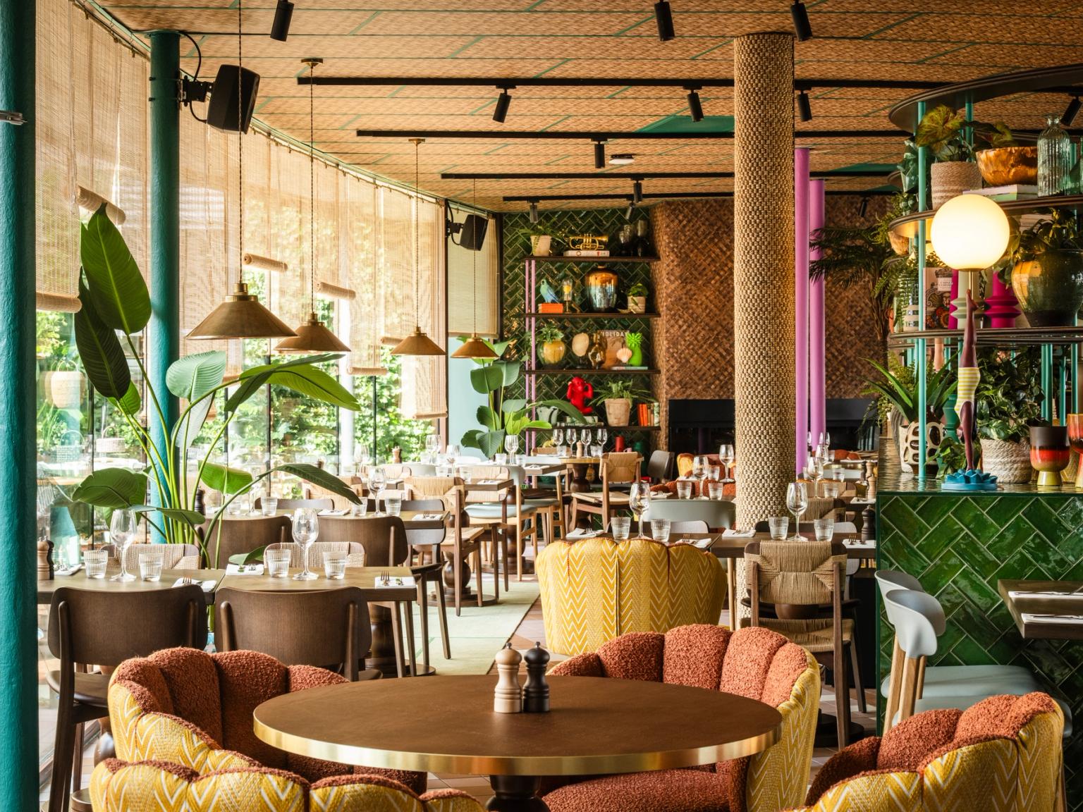 en restaurang fylld med bord och stolar och många fönster
