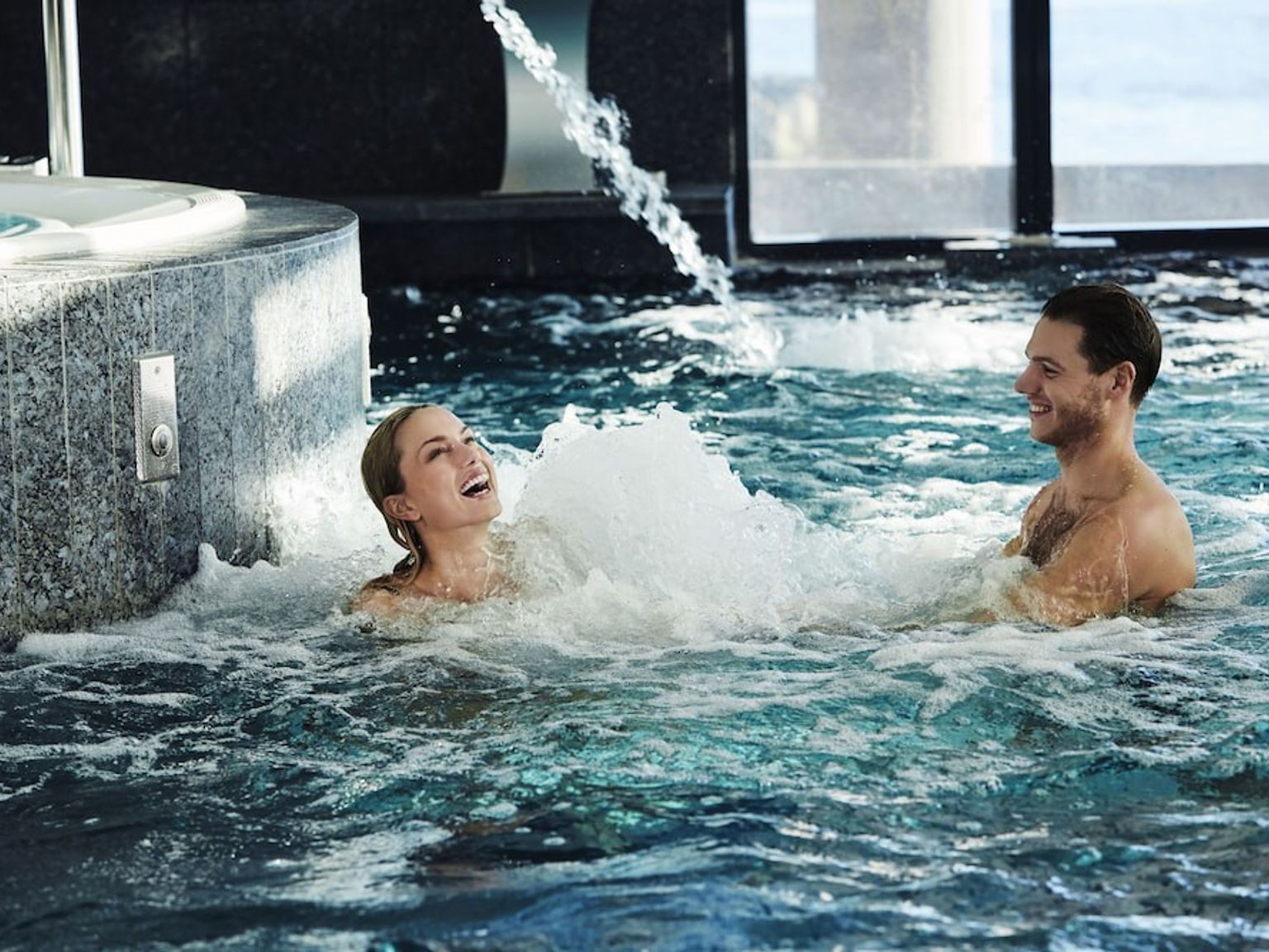 en mann og en kvinne leker i et svømmebasseng