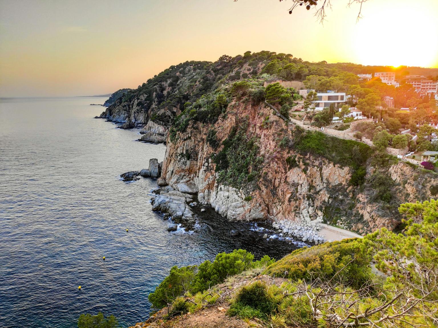 une vue d'une falaise surplombant l'océan au coucher du soleil