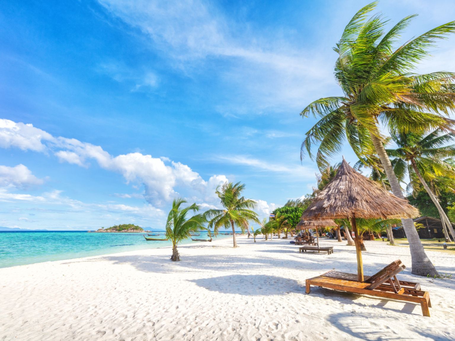 det er mange stoler og parasoller på stranden, Koh Lipe, Thailand