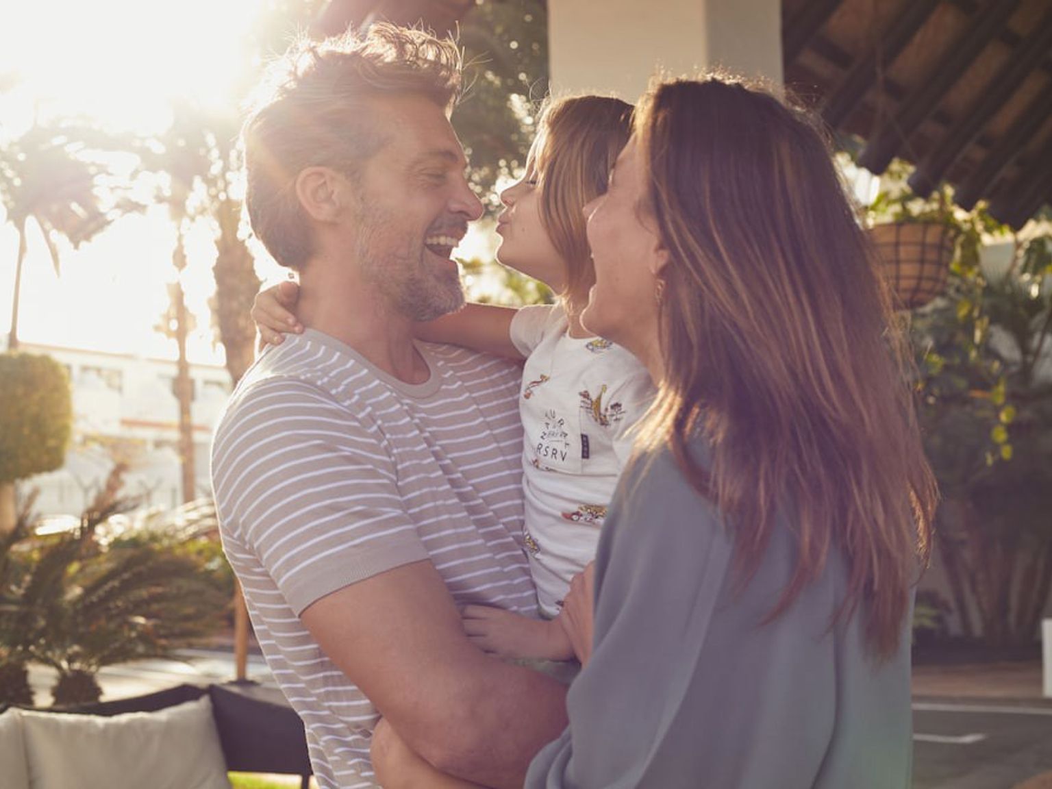 een man en vrouw houden een klein meisje in hun armen.