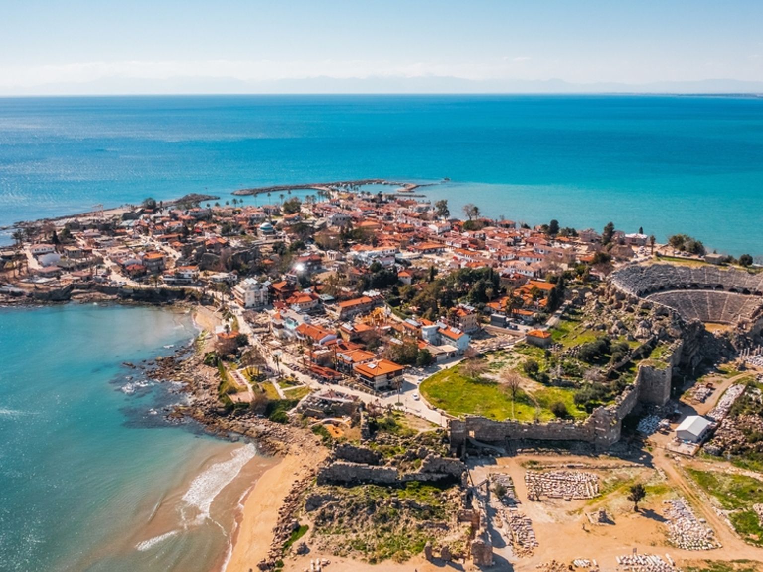 Luftfoto af en kystby og et gammelt amfiteater ved et turkis hav. Side, Tyrkiet