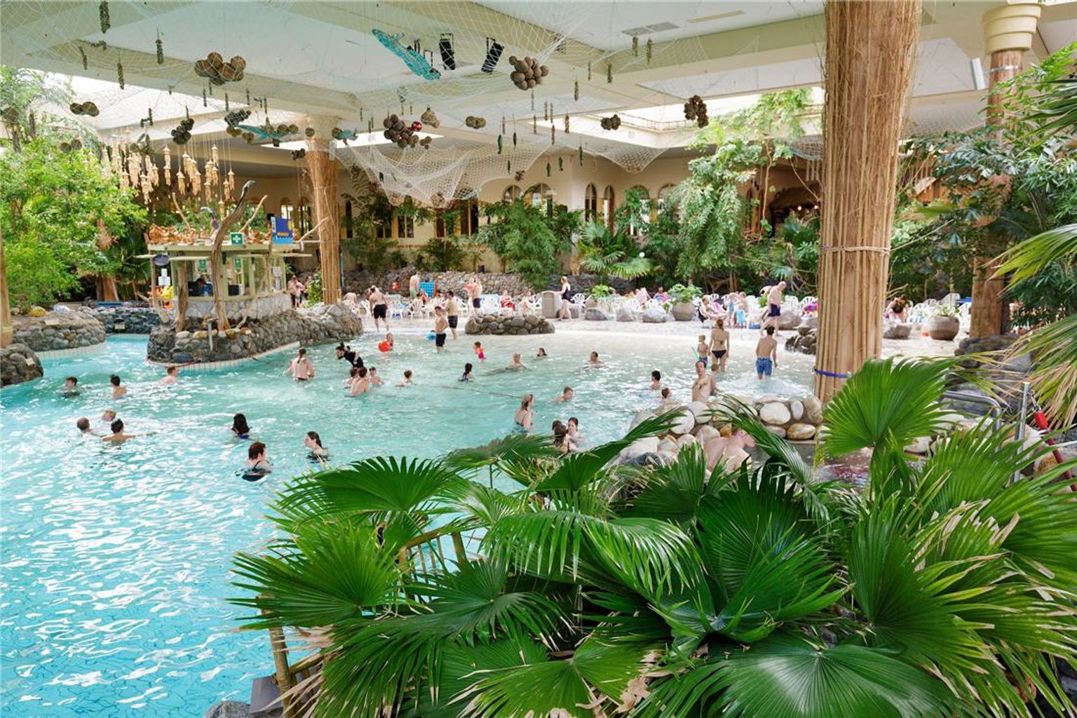 Bruisend indoor tropisch waterpark met een groot zwembad en weelderige planten. Center Parcs Park Hochsauerland