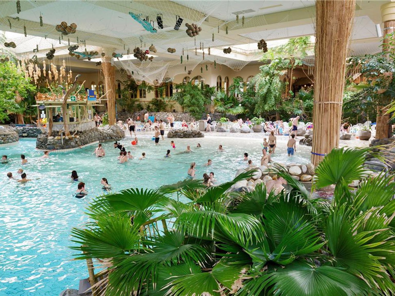 Bruisend indoor tropisch waterpark met een groot zwembad en weelderige planten. Center Parcs Park Hochsauerland