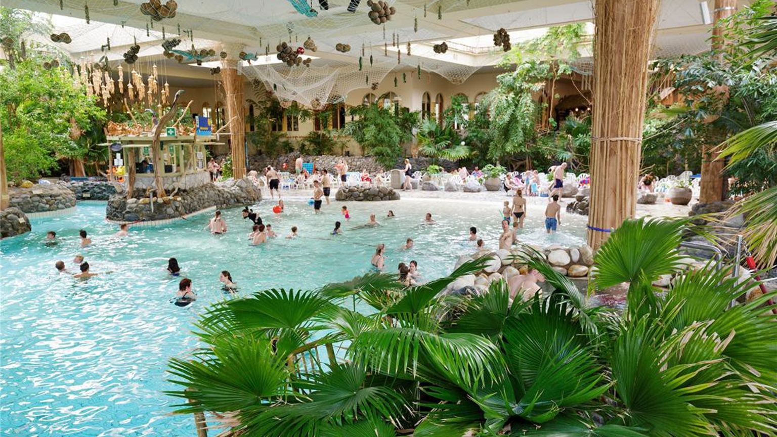 Bruisend indoor tropisch waterpark met een groot zwembad en weelderige planten. Center Parcs Park Hochsauerland