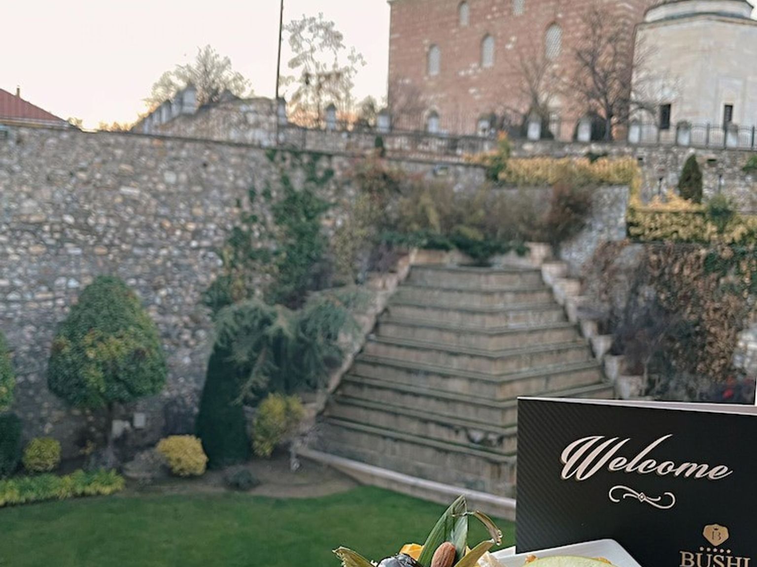 en tallerken med frukt sitter foran et velkomstskilt