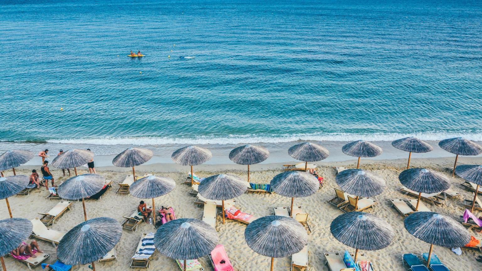 es gibt viele Regenschirme und Stühle am Strand