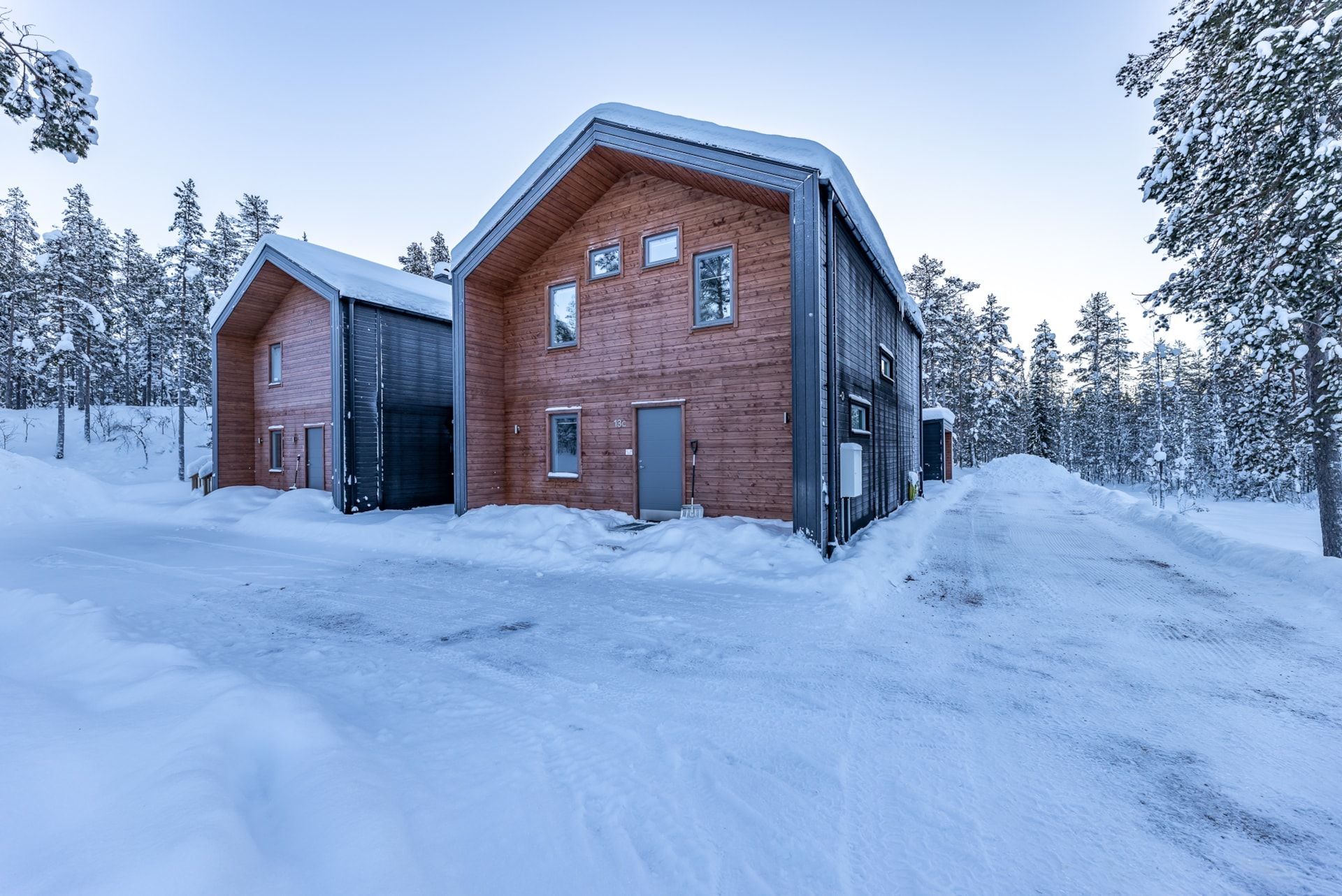 a large wooden house is surrounded by snow and trees.