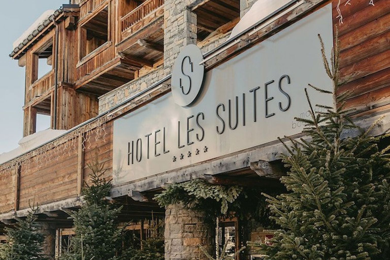 een hotel met een bord dat zegt hotel les suites, Hôtel Les Suites - Maison Bouvier