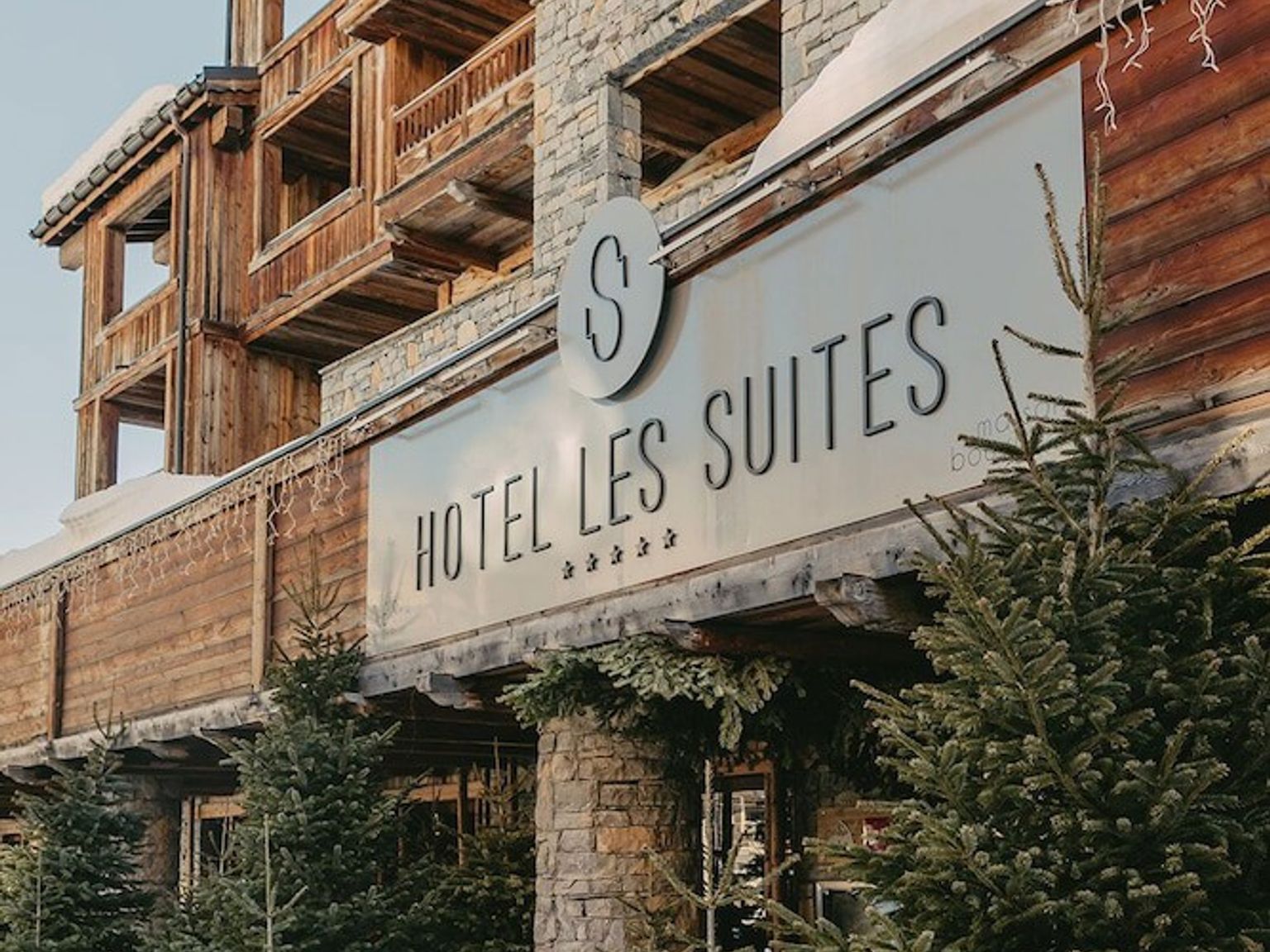 et hotell med et skilt som sier hotel les suites, Hôtel Les Suites - Maison Bouvier