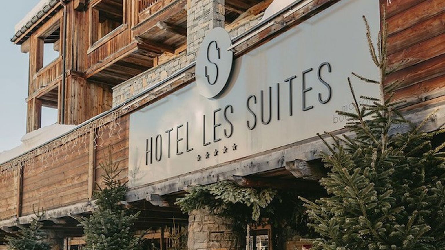 een hotel met een bord dat zegt hotel les suites, Hôtel Les Suites - Maison Bouvier