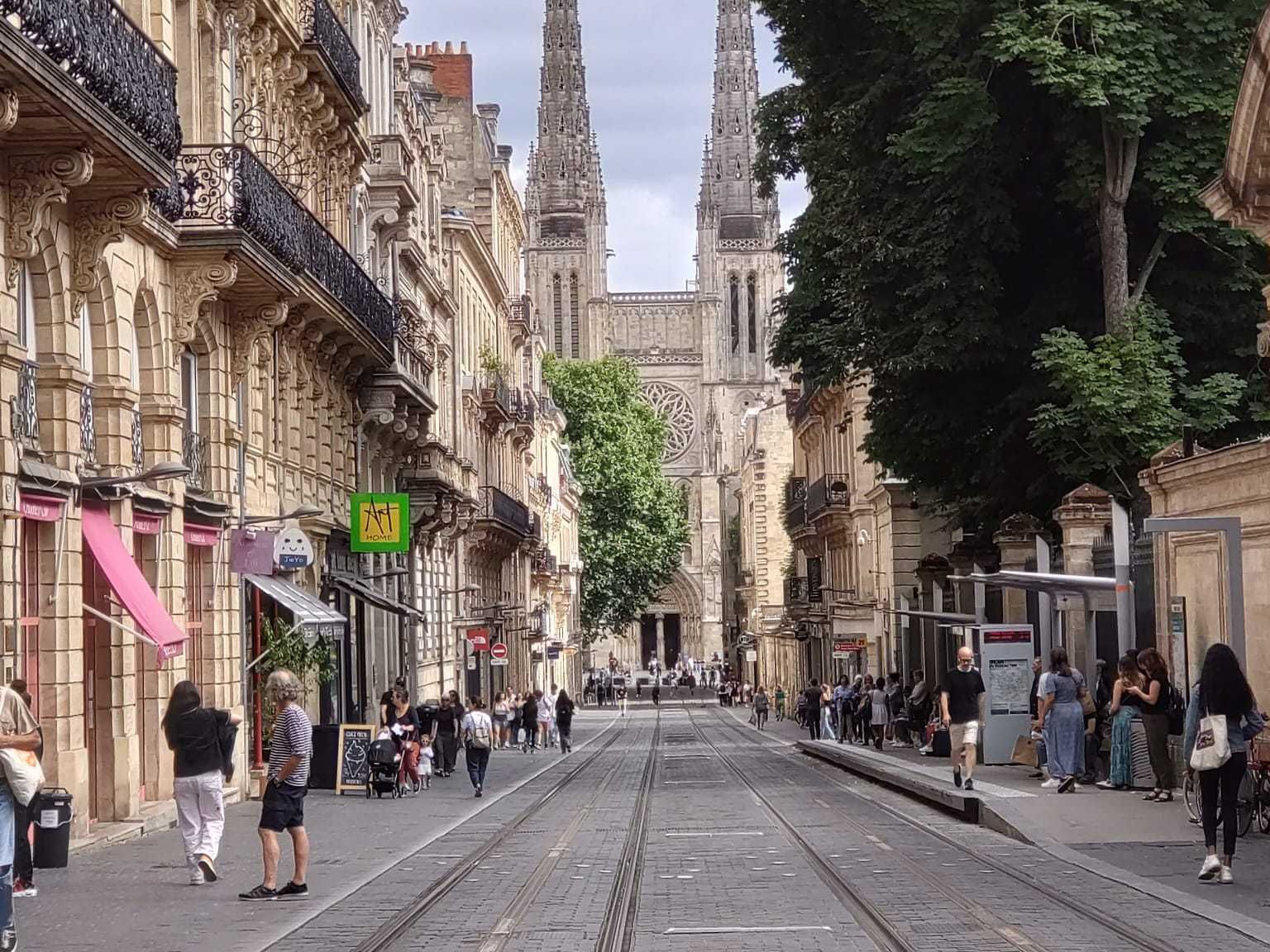 people walking down a street in front of a building with a sign that says 'sn' on it
