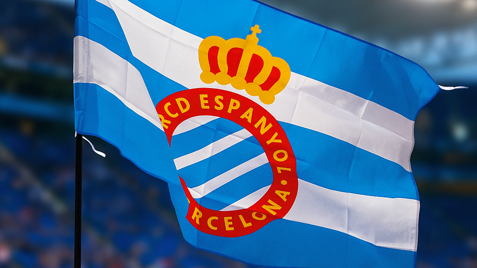 An RCD Espanyol flag waving in a football stadium.