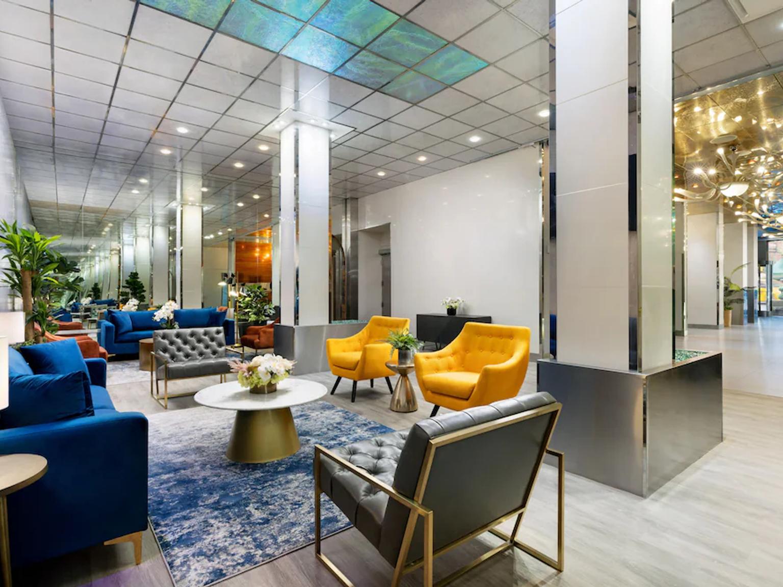 det finns många stolar och en soffa i lobbyn på ett hotell