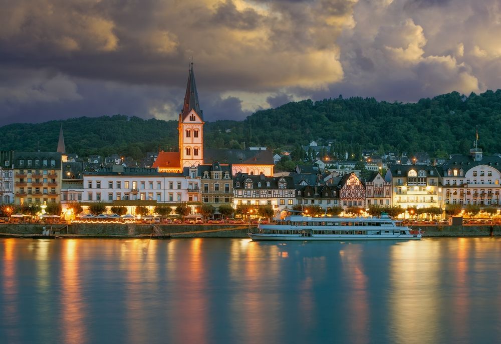 a boat is floating on the water in front of a city at night.