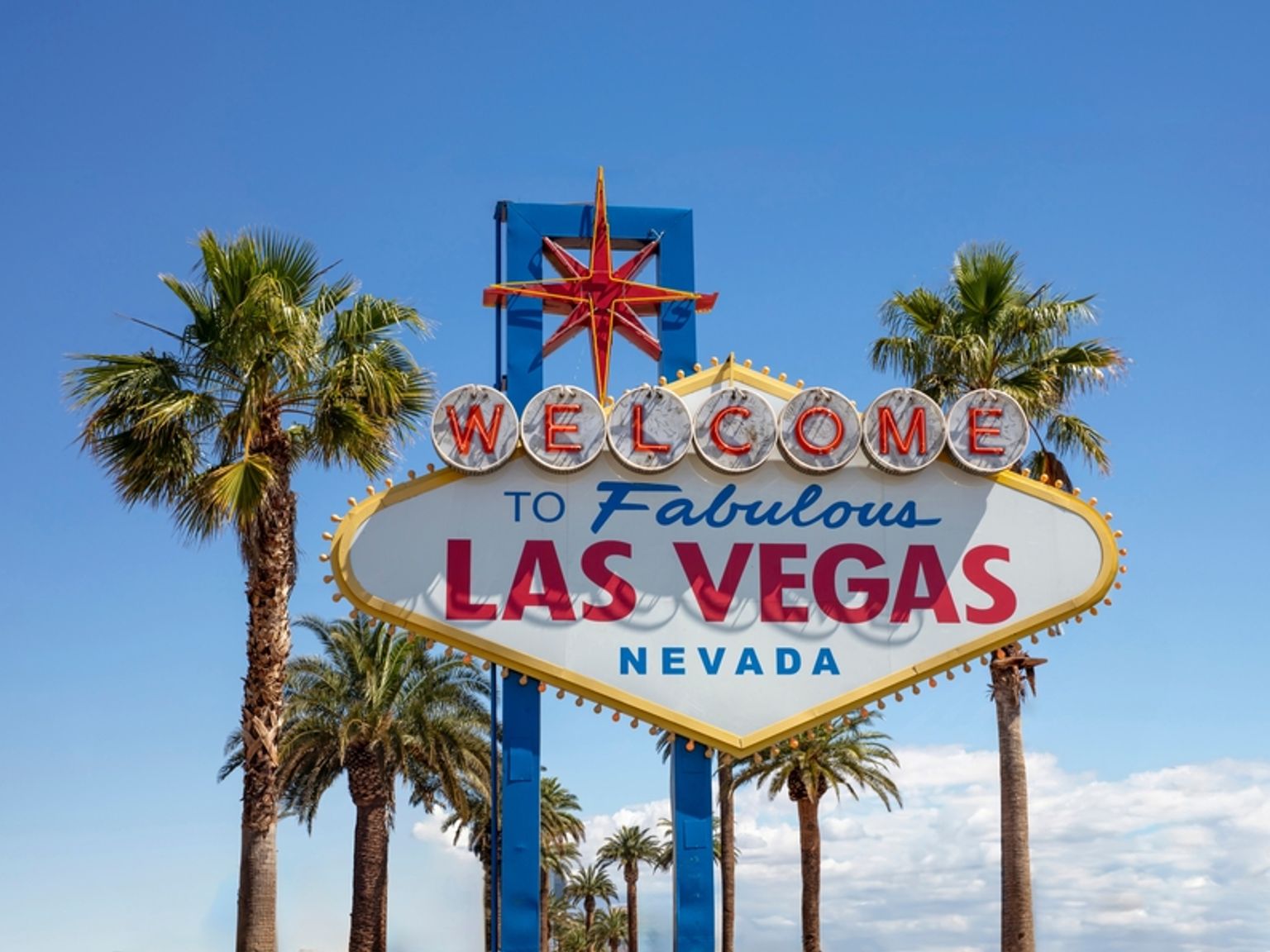 Det ikoniske Welcome to Fabulous Las Vegas-skiltet med palmer mot en blå himmel. Las Vegas