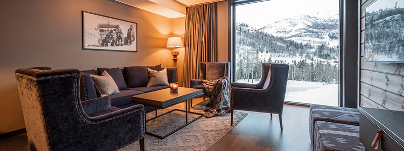 en stue med en sofa, stole og et stort vindue.