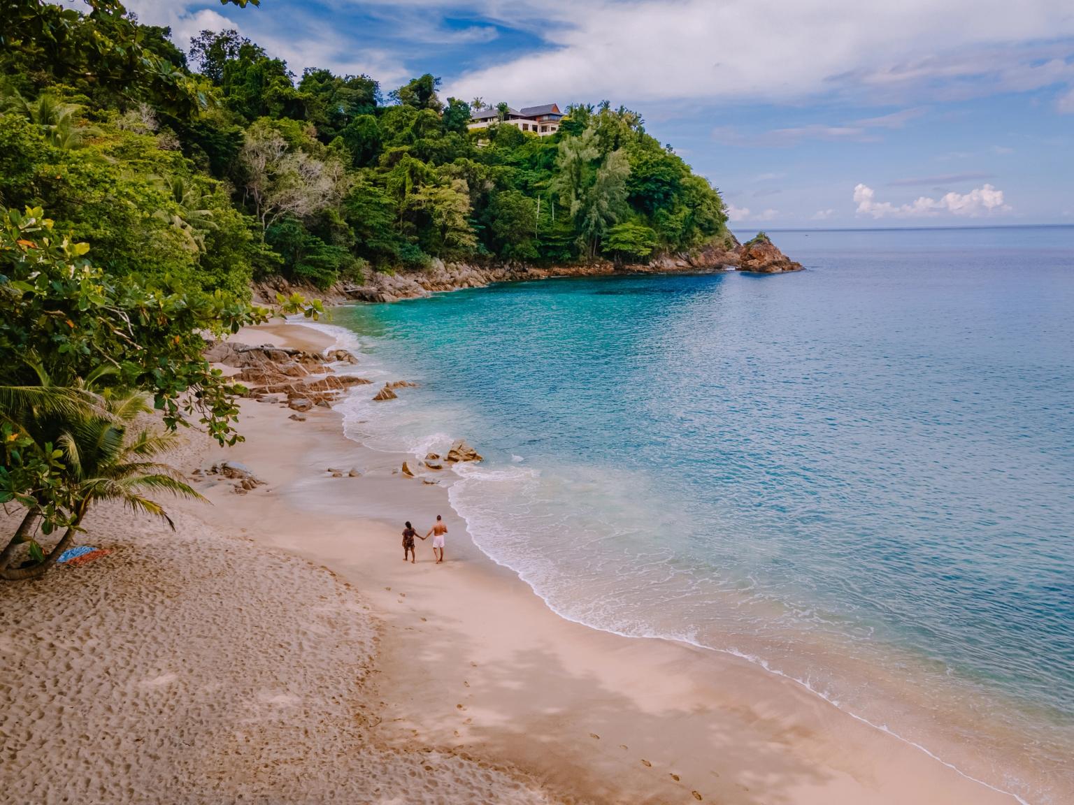 et par går langs en sandstrand nær havet