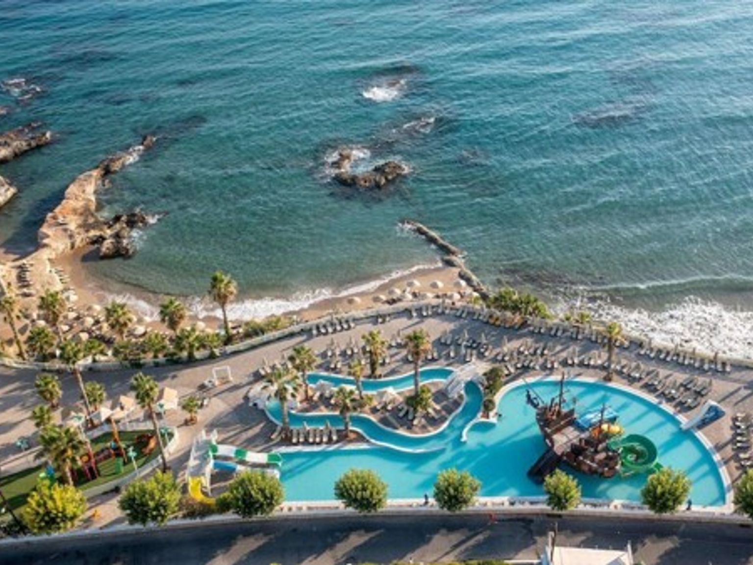 en luftig utsikt over et stort svømmebasseng ved siden av havet