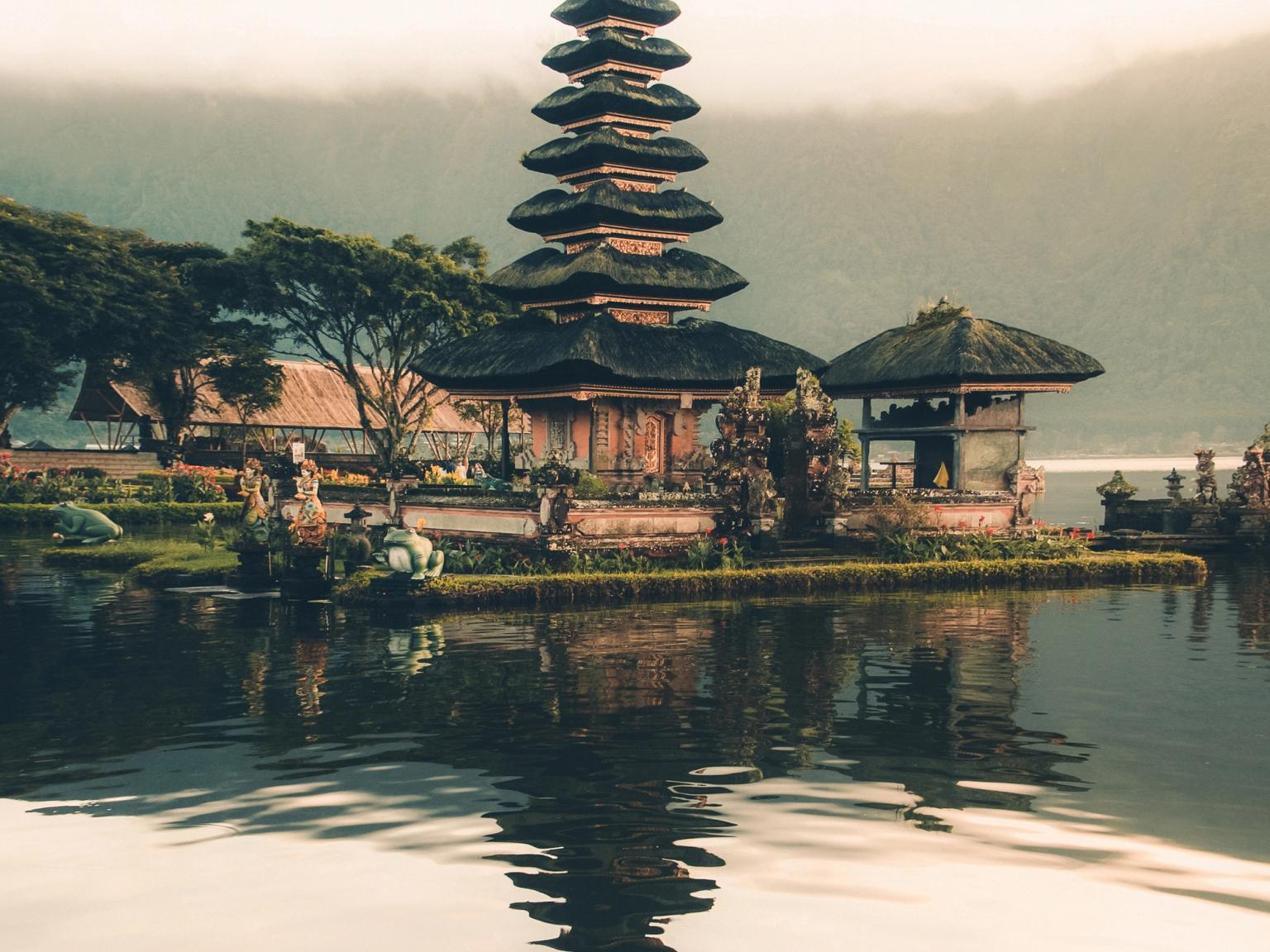 ett tempel speglas i vattnet av en sjö pÄ Bali.