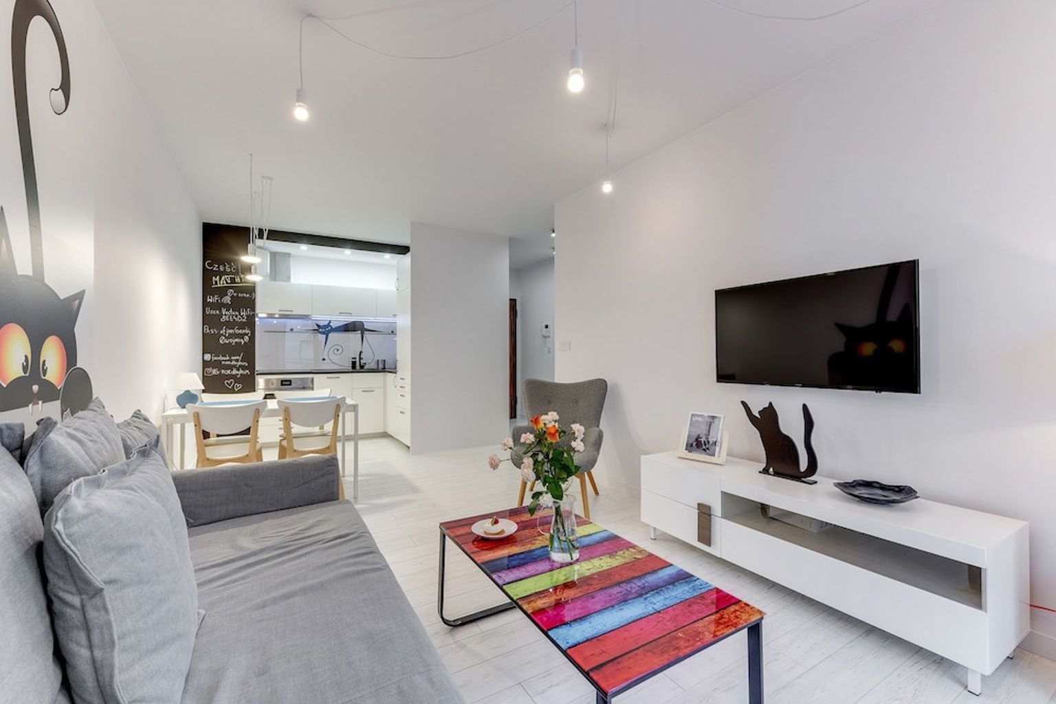 en stue med en sofa, sofabord og fjernsyn