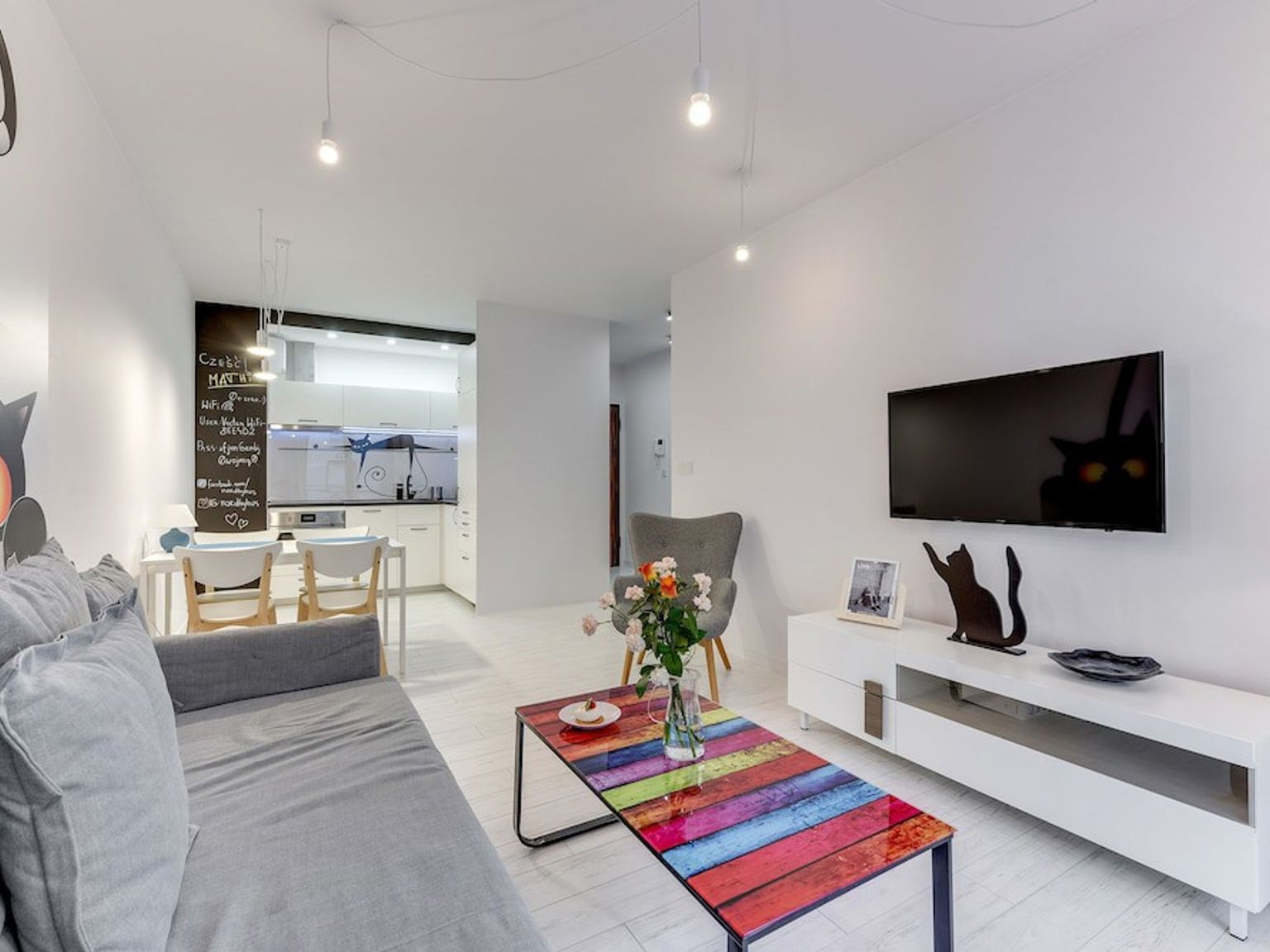 ett vardagsrum med en soffa, soffbord och tv