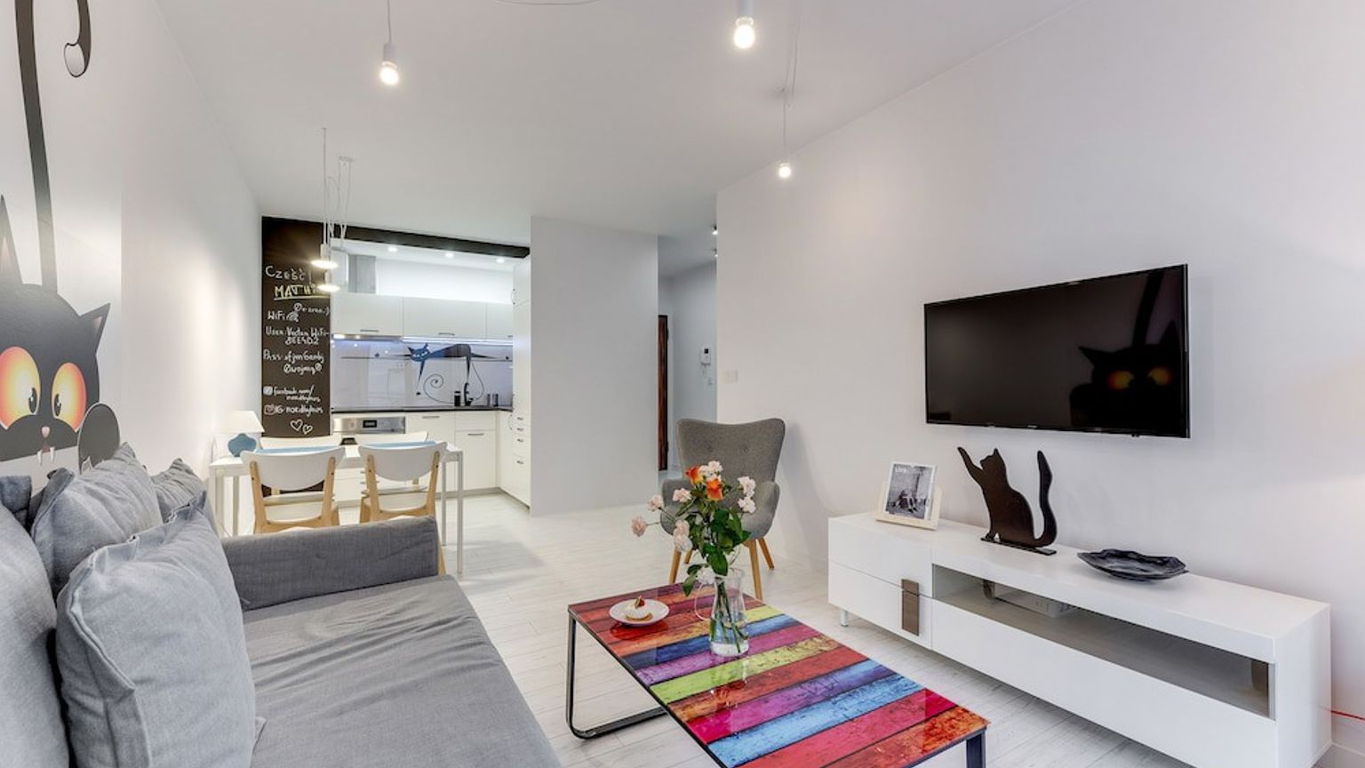 en stue med en sofa, sofabord og fjernsyn