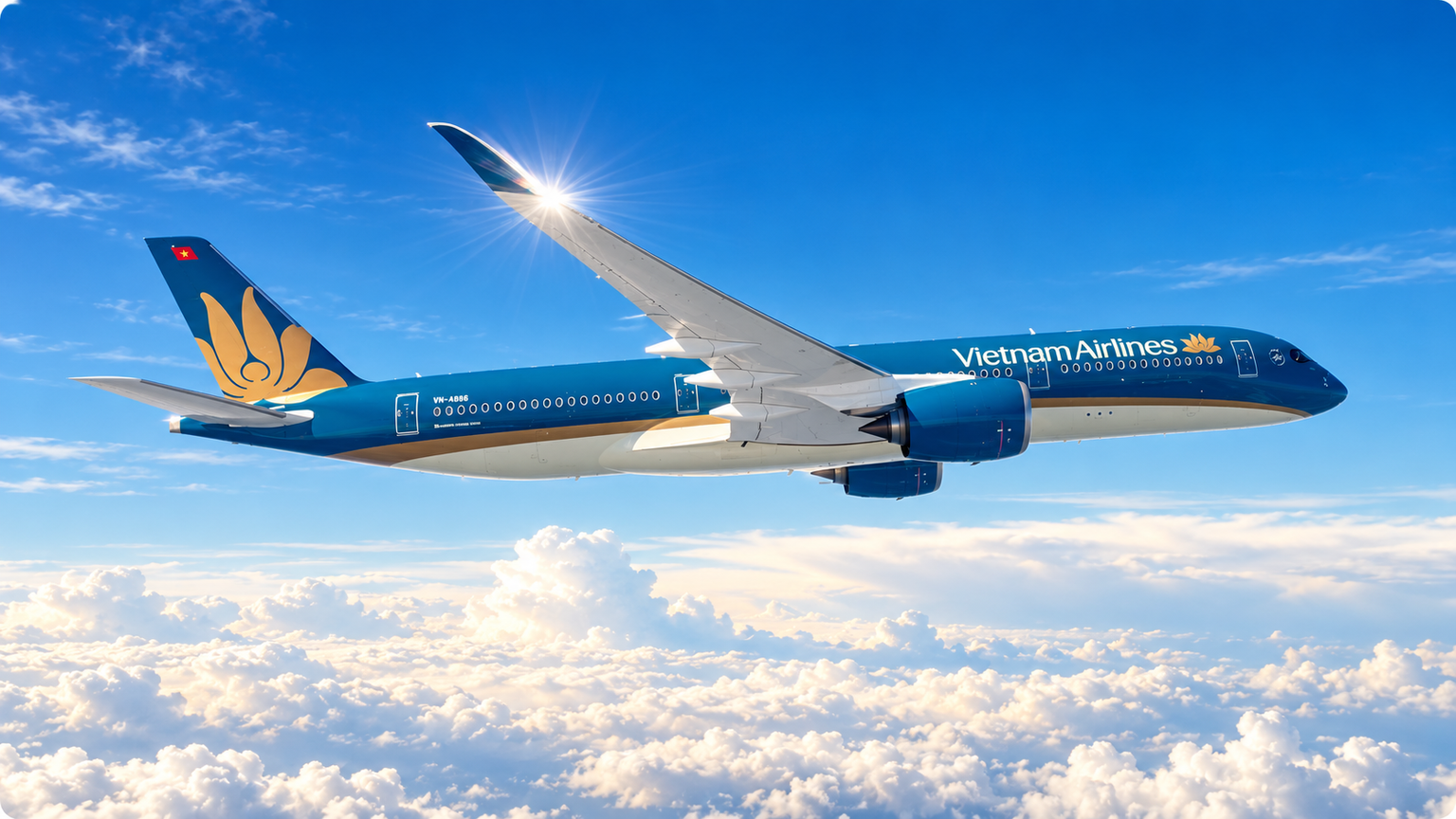 Et blåt og guldfarvet fly fra Vietnam Airlines flyver over hvide skyer under en klar blå himmel.