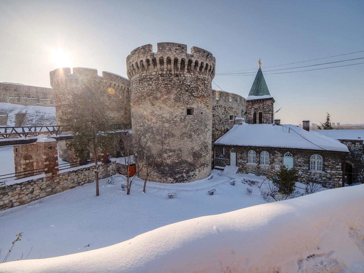 slottet är täckt av snö och solen skiner genom snön