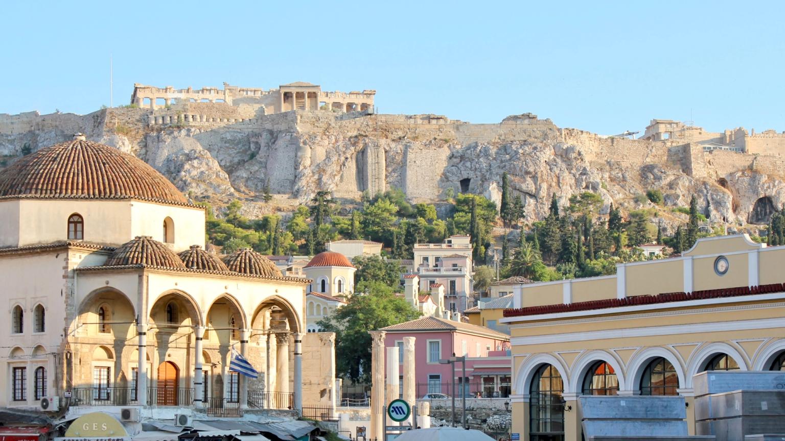 en menneskemængde går i en by med et slot i baggrunden