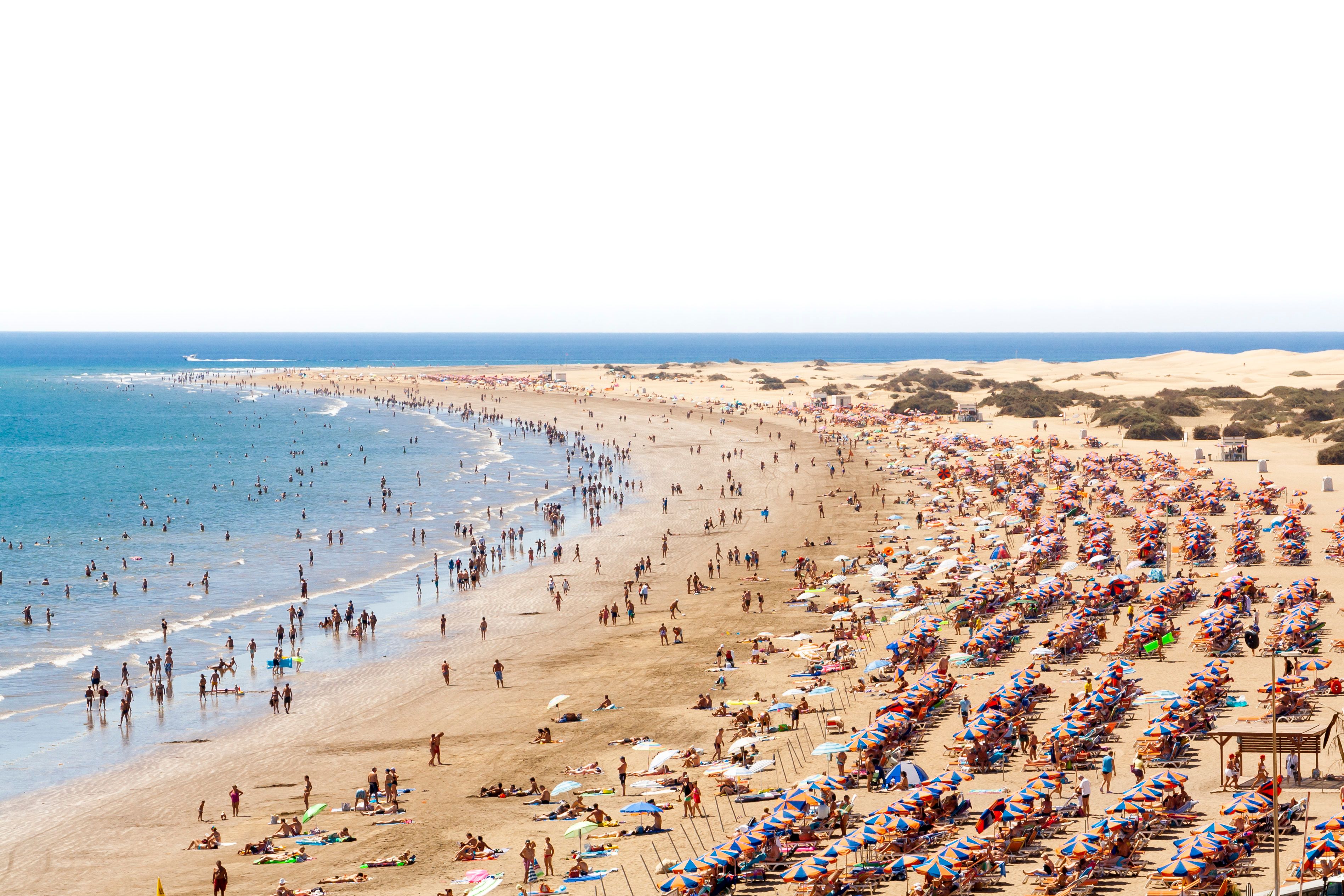 en meget overfyldt strand med masser af mennesker og paraplyer