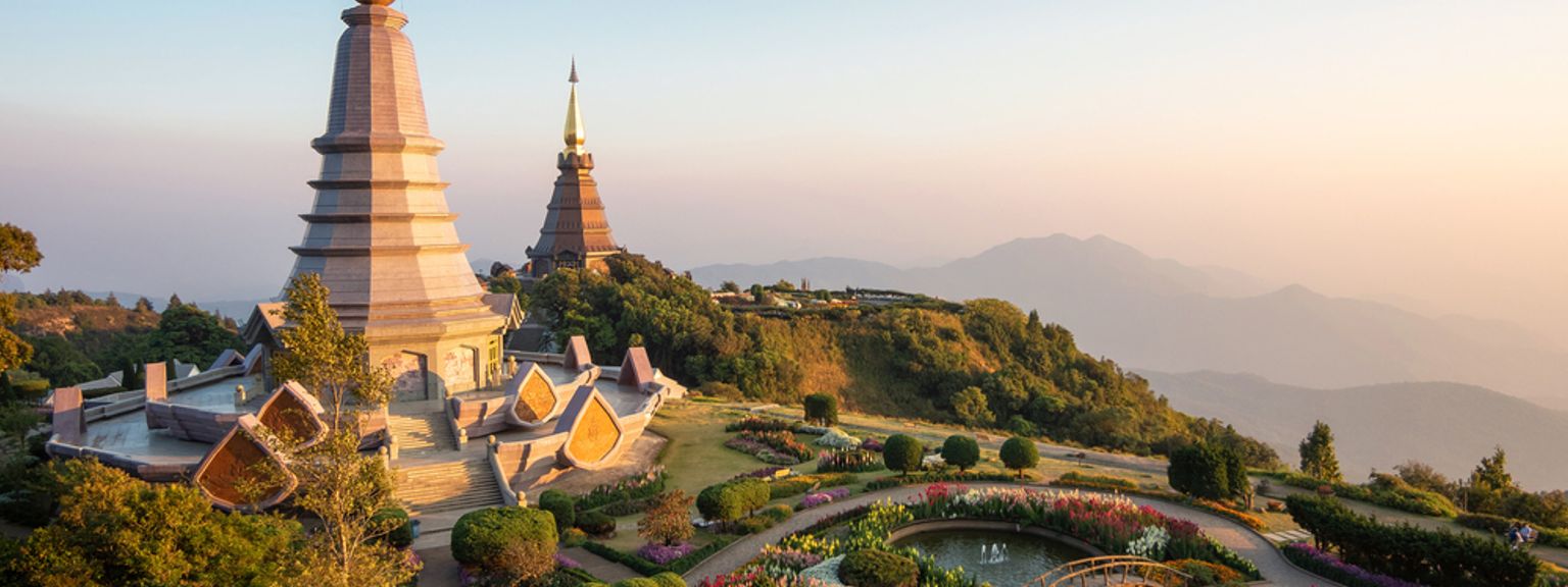ett tempel på toppen av en kulle omgiven av blommor och träd, Chiang Mai - Thailand
