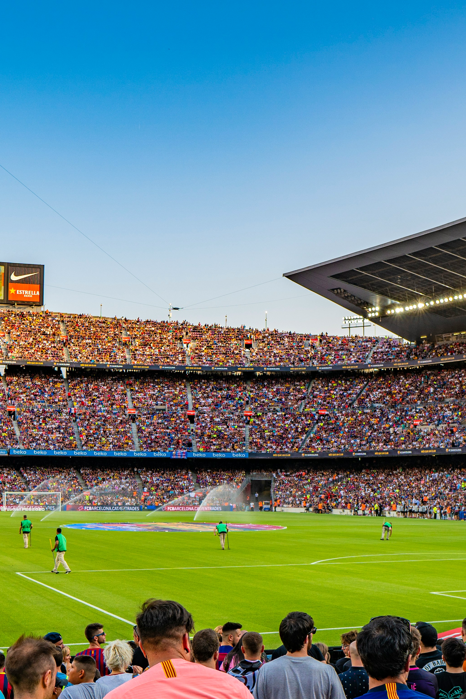 Vollbesetztes Fußballstadion mit Spielern auf dem Feld.