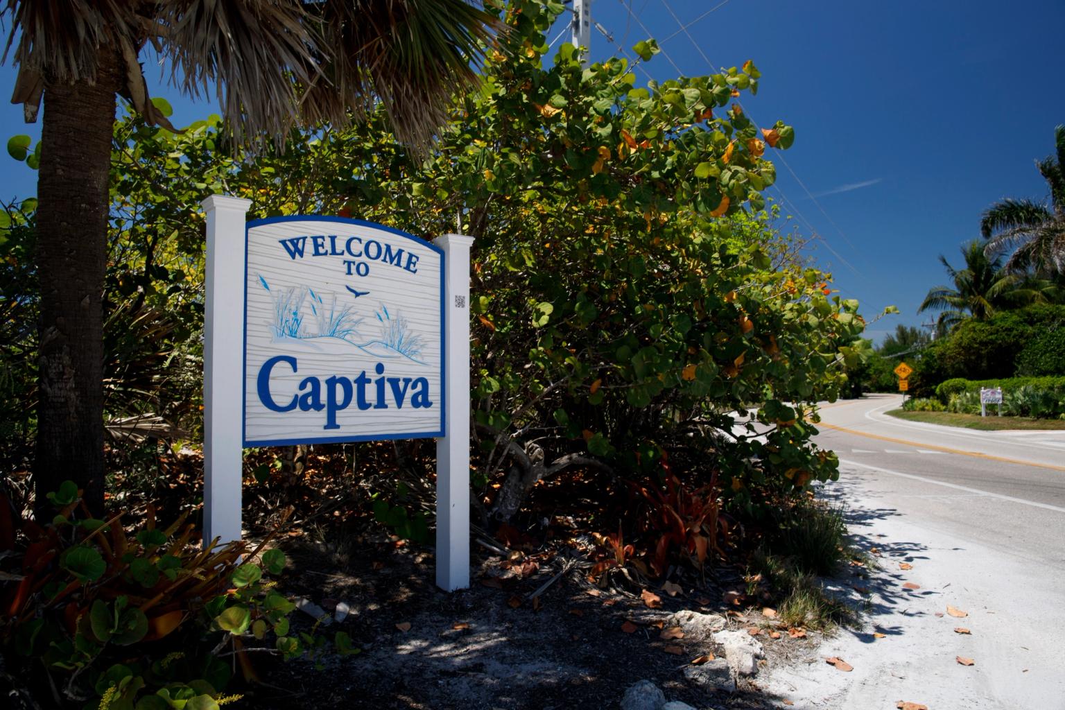 et velkomstskilt til Captiva står ved siden av en vei.