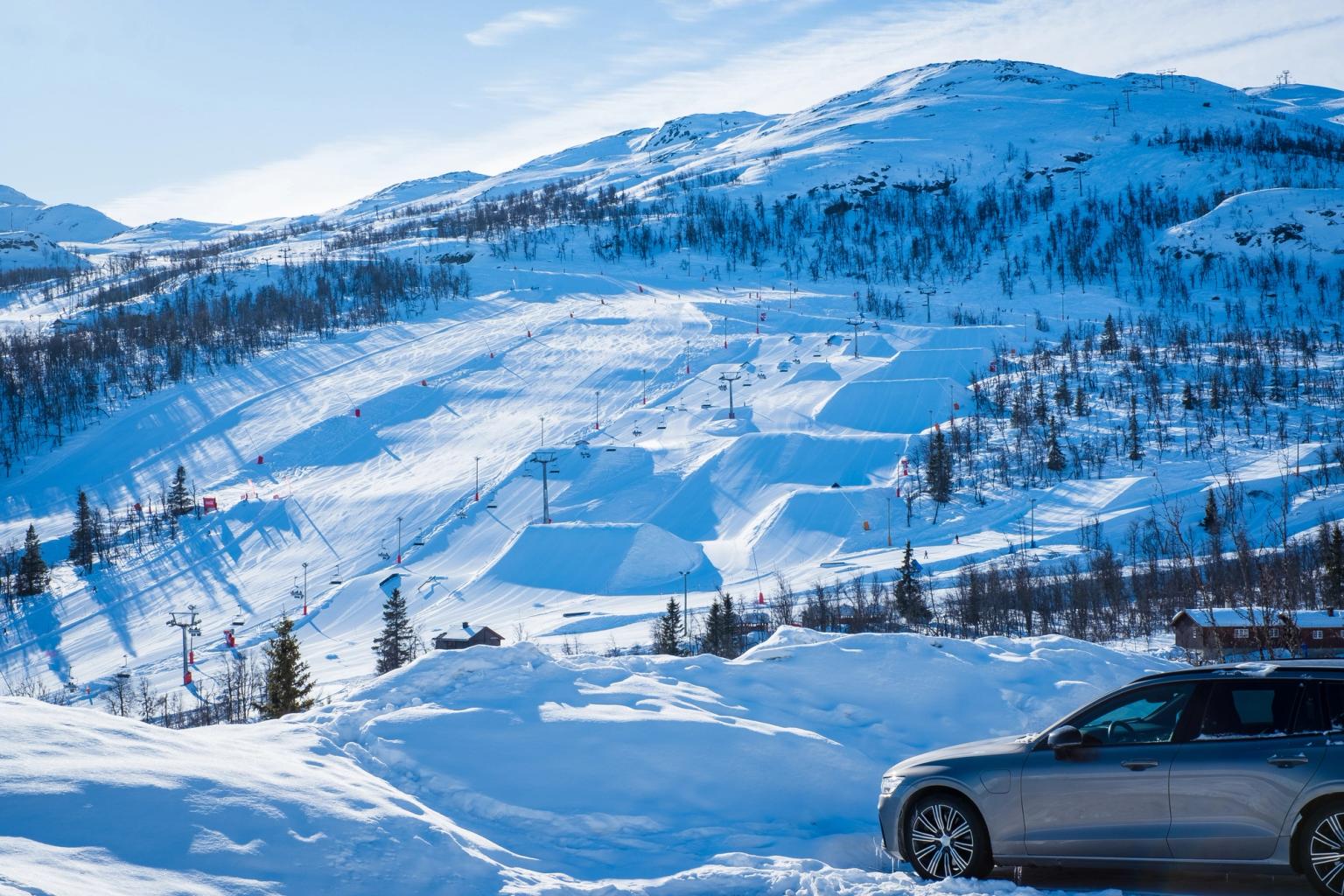 samochód jest zaparkowany na śniegu w pobliżu ośrodka narciarskiego