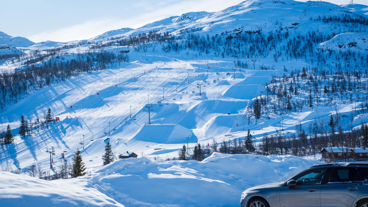 samochód jest zaparkowany na śniegu w pobliżu ośrodka narciarskiego