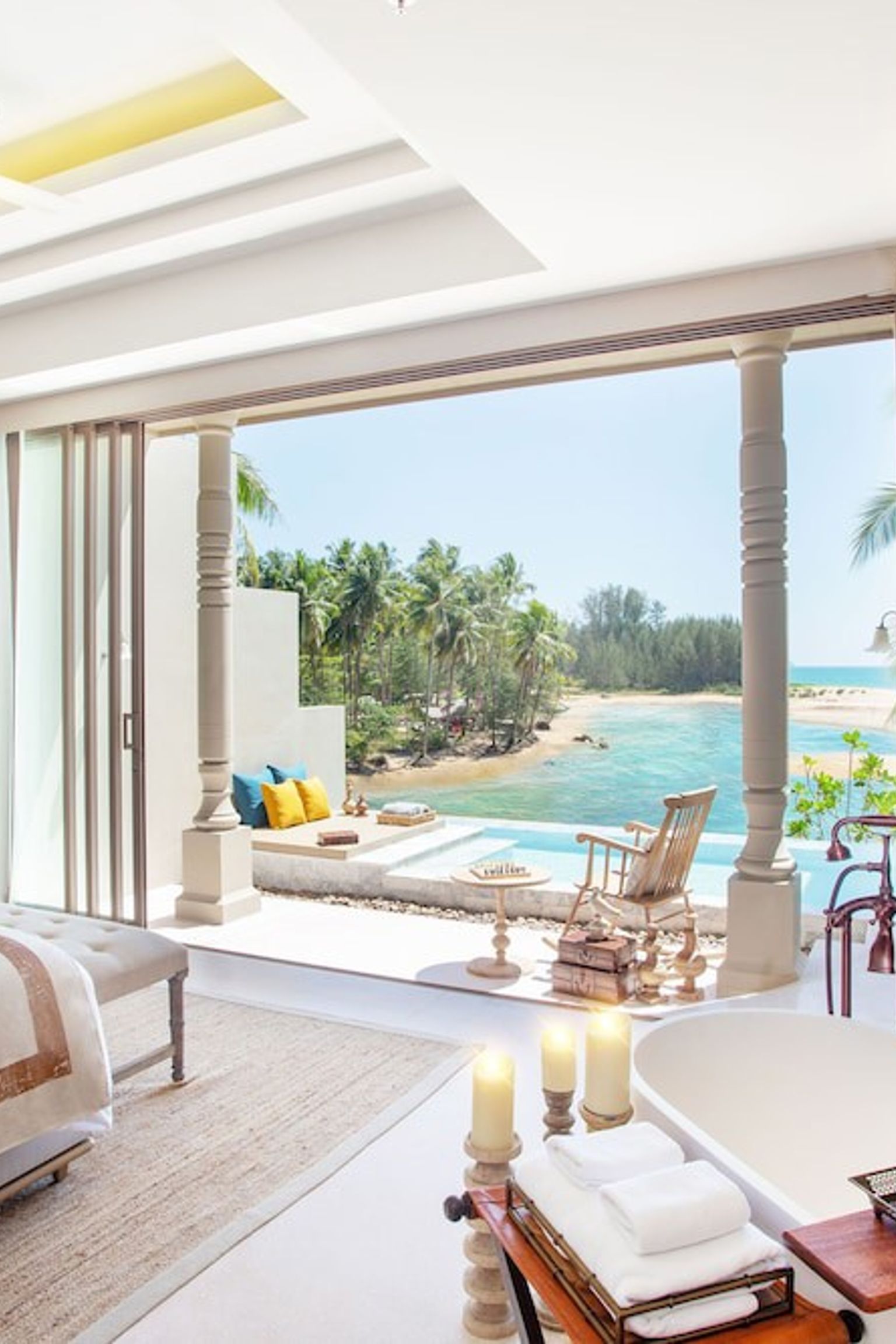 a bedroom with a bathtub and a view of the ocean