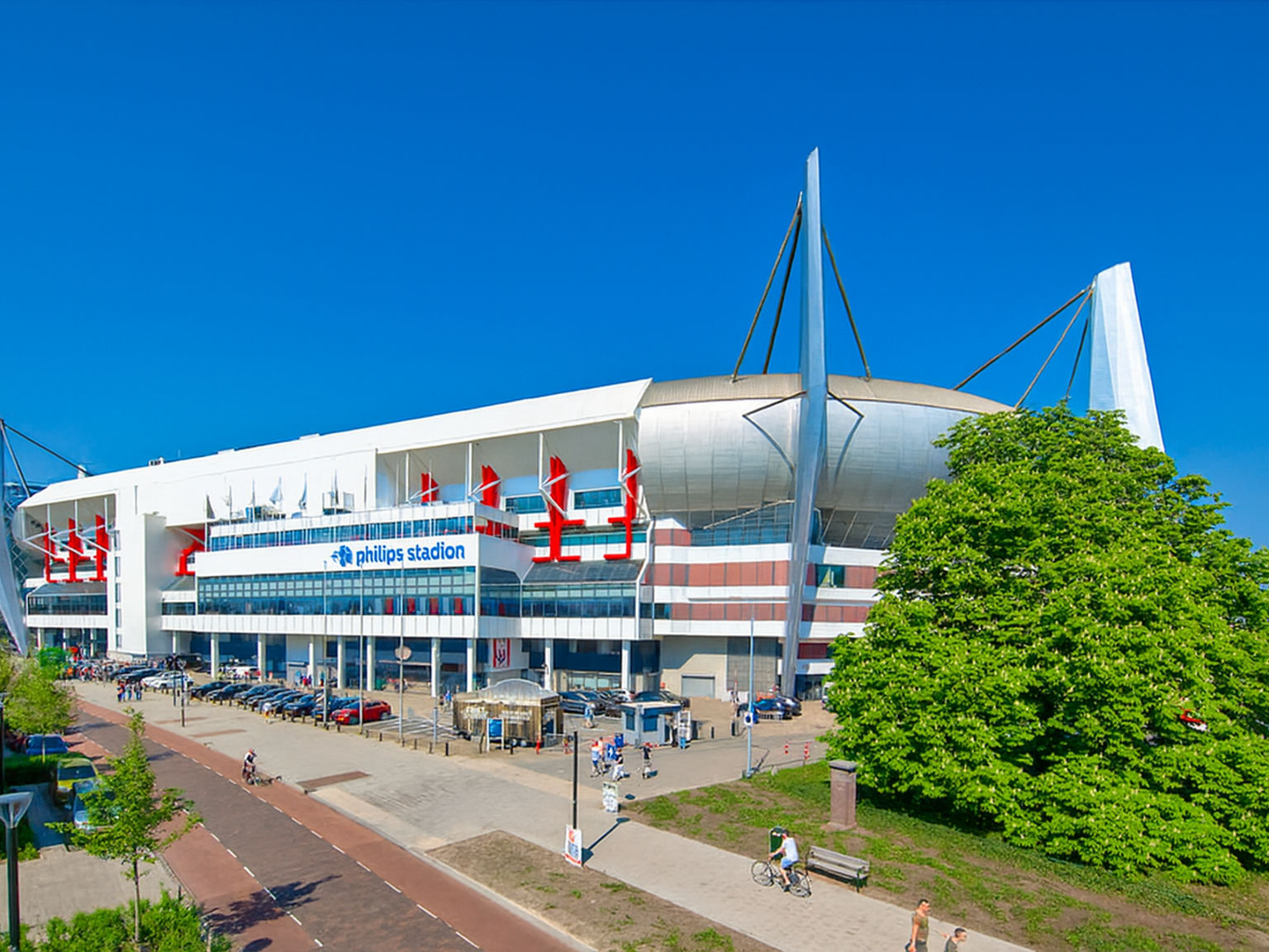 Außenansicht des modernen Philips Stadions unter einem strahlend blauen Himmel.