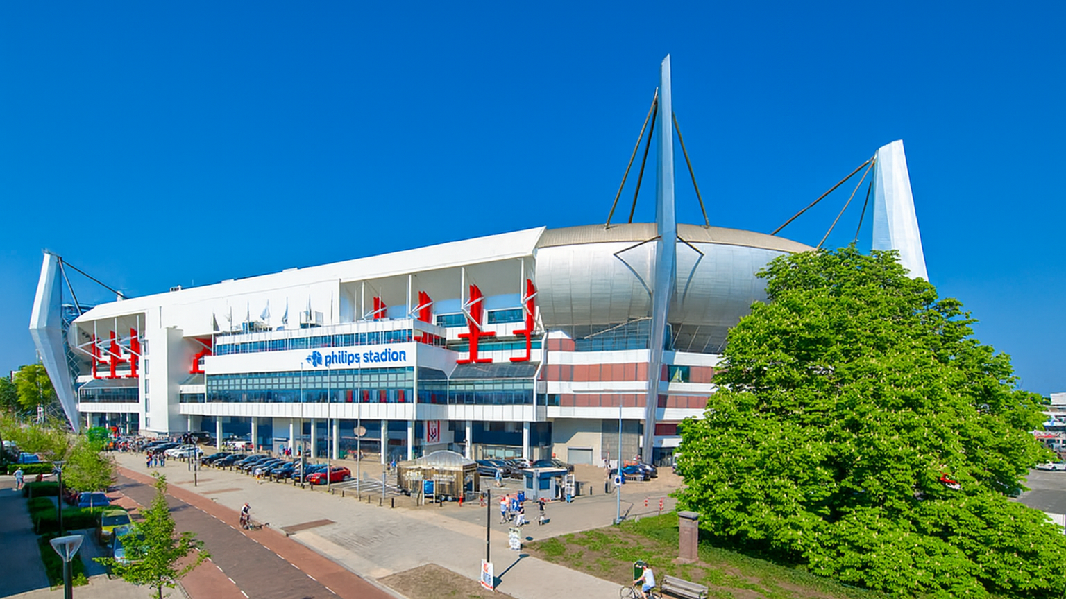 Außenansicht des modernen Philips Stadions unter einem strahlend blauen Himmel.